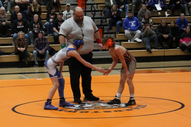 Good luck! Tristan Belleville shakes hands with an Auburn Trojan prior to their wrestling match.