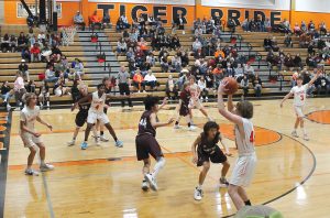 The Tiger’s Parker McCoy looks to feed the ball inside to Ephrem Kayembe (#4).