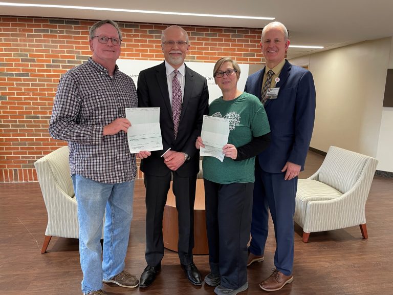 Kevin Eckhoff, JMH 5K/10K Race director, second from left, presents checks for $2,282.93 to Tom Prather, left, Cass County Food Pantry, and to Melissa Hall, Jacksonville Food Center. Trevor Huffman, JMH president and CEO, right, also attended the check presentation. Photo courtesy of Memorial Health.