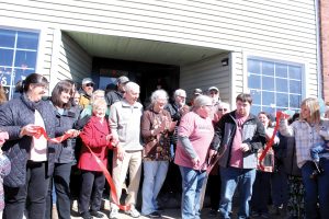 Jill Roegge and Isaac French cut the ribbon in front of their new coffee shop location.