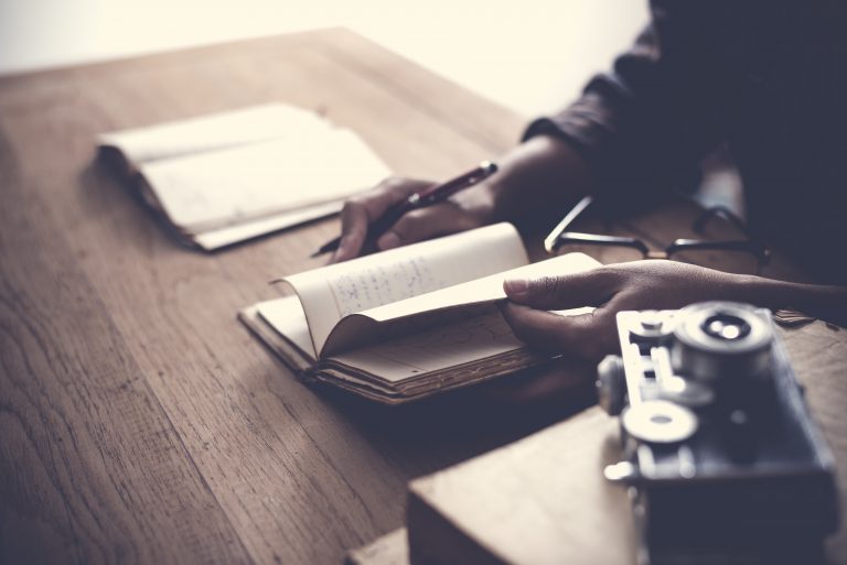 home office desk background, Desk musicians, hand holding pencil and writing note on wood table,Checklist Notice Remember Planning Concept