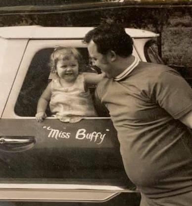 Buffy smiles at her dad, Chuck, while standing in the front seat of her Grandpa’s truck.