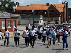 Chants of "Stop the Genocide" filled the air as members of the Congolese Community were escorted by the Beardstown Police Department and the Cass County Sheriff's Department to Art Zeeck Park.