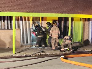 Firefighters cut through tbe bars covering the front door at La Frontera Grocery Store. Photo by Jaime Chapman
