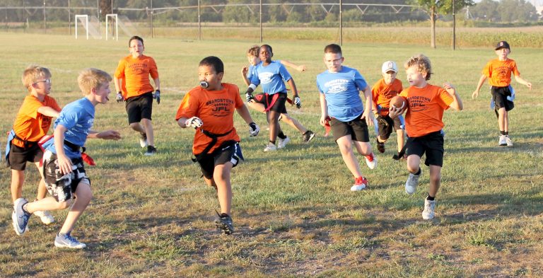 The runner heads for the corner on the outside sweep in Beardstown JFL Flag Football action.