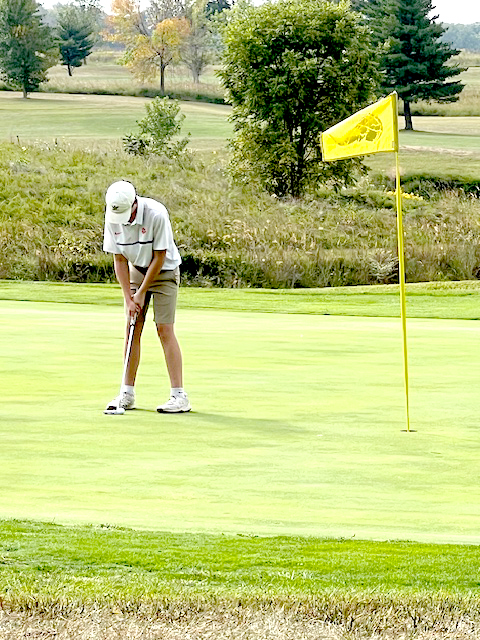 Carter Ross lines up a putt for the Tiger golf team.