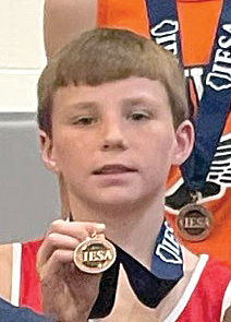 Virginia-Triopia’s Corbin Beck shows off his medal for placing 11th at the IESA Class 2A State Cross Country Meet.