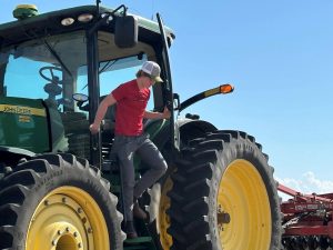 Charlie Roegge climbs down from his tractor after tilling a soybean field near his home in Cass County. Photo by Tammie Sloup of FarmWeek