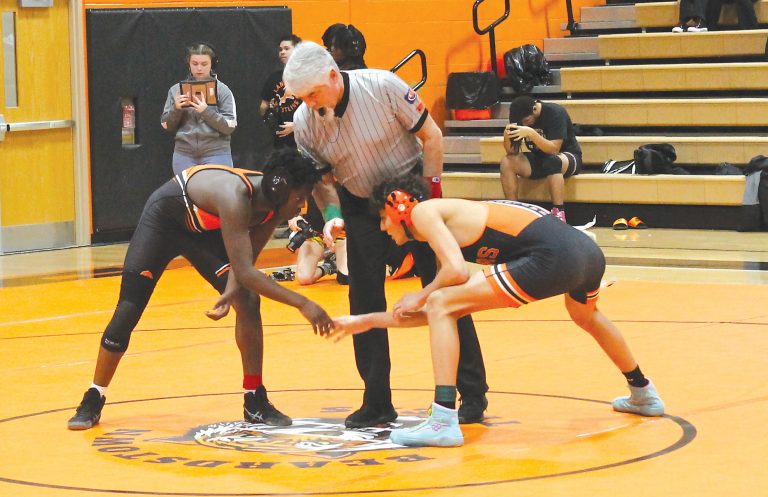 Maddox Medrano shakes hands with a Lanphier wrestler prior to their match.