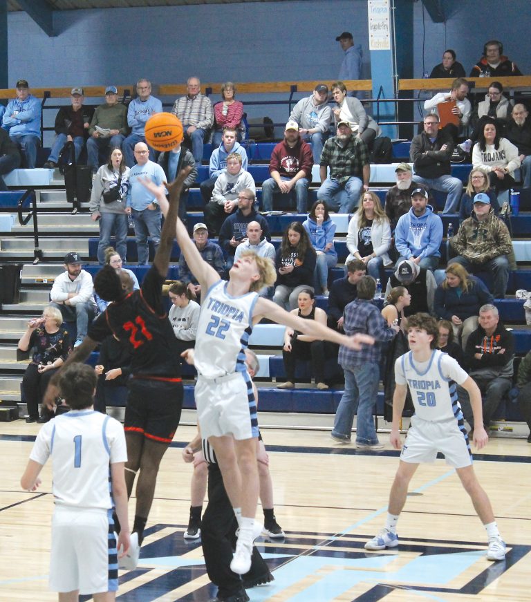 The Tigers Cleon Djafalo and the Trojans Andrew Hobrock go up for the varsity tip off.